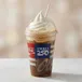 Root beer, Coke, or other soda flavored float topped with vanilla soft serve